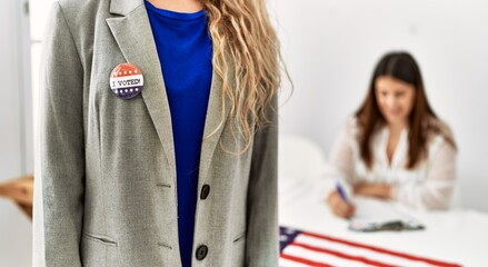 Young american voter woman holding i voted badge standing at electoral college.