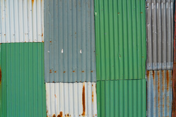 corrugated metal wall patched and rusty