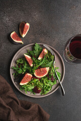 Figs, beetroot, arugula and walnuts salad. Black background, top view