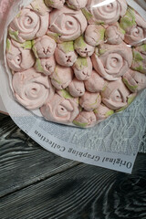 Marshmallow bouquet in paper packaging. Zephyr in the form of roses and tulips. In pink. Close-up shot.