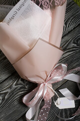 Bouquet wrapped in wrapping paper. Tied with a ribbon tied to a bow.