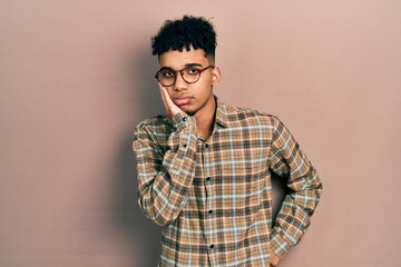 Fototapeta na wymiar Young african american man wearing casual clothes and glasses thinking looking tired and bored with depression problems with crossed arms.