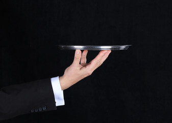 hand of a waiter with a tray on a black background - Powered by Adobe