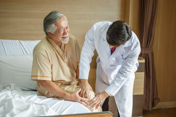 Obraz premium doctor examining the knee and leg after surgery of asian senior old man patient suffering from pain in knee on bed in medical office room at hospital . diversity people