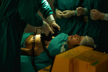 The medical team and nurses  defibrillating male patient in the operating room . group of surgeon work in surgery room - obrazy, fototapety, plakaty