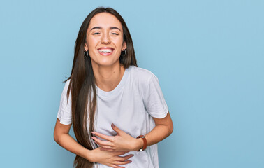 Young hispanic girl wearing casual white t shirt smiling and laughing hard out loud because funny...
