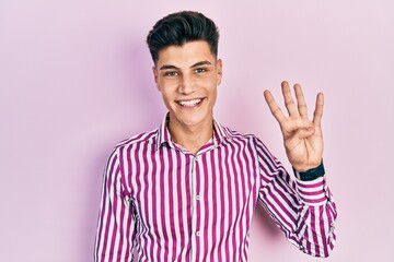 Naklejka premium Young hispanic man wearing casual clothes showing and pointing up with fingers number four while smiling confident and happy.