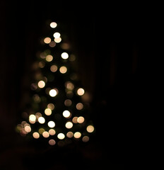 Defocused lights on a black background in the form of a fir. Bokeh