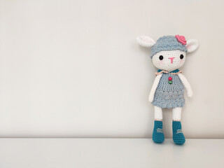 Amigurumi toy, cute little lamb soft knitted toy with copy space on white background