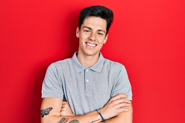 Young hispanic man wearing casual clothes happy face smiling with crossed arms looking at the camera. positive person.