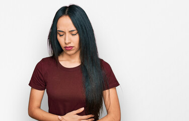 Young hispanic girl wearing casual t shirt with hand on stomach because indigestion, painful illness feeling unwell. ache concept.