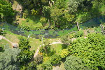 aerial view of the watercourse that crosses the gardens of ninfa in the country of cisterna di latina - obrazy, fototapety, plakaty