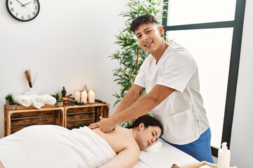 Woman smiling happy reciving back massage at the clinic. - obrazy, fototapety, plakaty