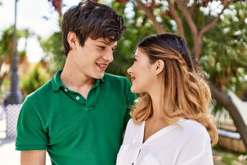Obraz premium Young caucasian couple smiling happy and hugging standing at the city.