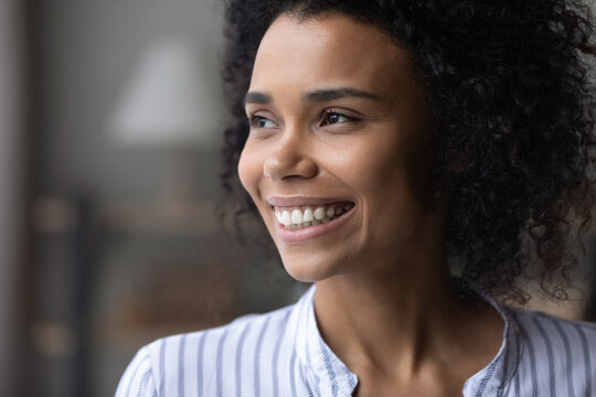 Positive Thinking. Close Up Of Attractive Young Black Lady With Beautiful Smile On Face Look At Distance Feel Glad Happy Motivated. Pleasant Millennial Biracial Woman Enjoy Good Mood Dreams Of Future