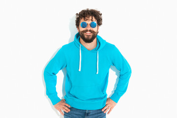 casual man wearing sunglasses, holding his hands in his hips