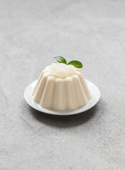 Vegan dessert, vanilla melon Panna Cotta on a plate on a light gray background