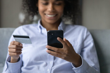 Easy online shopping. Close up shot of credit bank card and mobile telephone in hands of smiling...