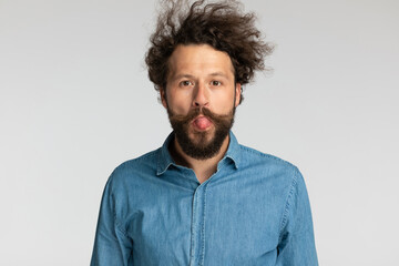 Fototapeta na wymiar goofy young bearded man sticking out tongue and making silly faces