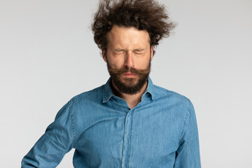 young casual man in denim shirt closing eyes and stopping the tears