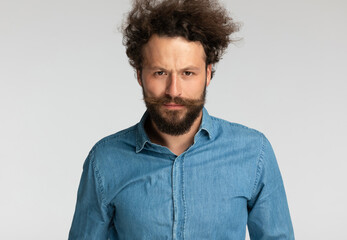 casual fashion model with beard making a serious face when frowning