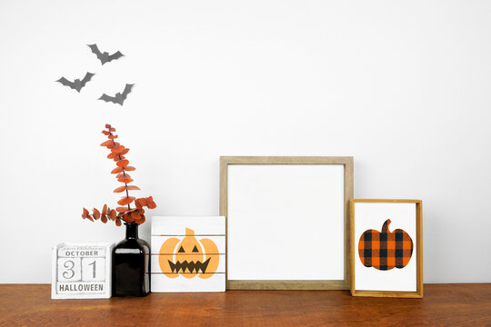 Halloween mock up. Shabby chic wood signs, calendar and orange branch decor on a wood shelf against a white wall. Copy space.