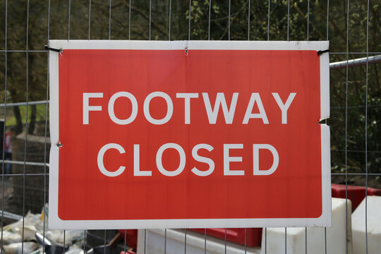 A red footway closed sign on an industrial site.