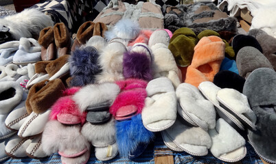 Fur home slippers on the counter.  Multicolored warm women's home shoes. 
