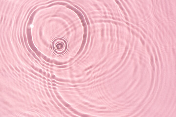 Texture wave from drops on pink water under sunlight. Top view, flat lay