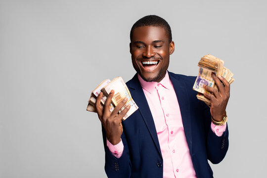 Happy Young African Man Holding A Lot Of Money That He Has Won, Feeling Excited