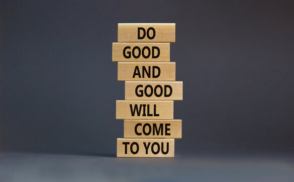 Concept of karma motivational words. Wooden blocks on the stack of wooden blocks. Words 'do good and good will come to you'. Beautiful grey background, copy space.