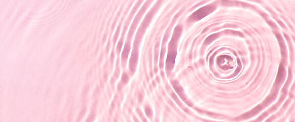 Texture of drops on pink water under sunlight. Top view, flat lay. Banner