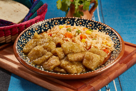Chicharr&oacute;n en salsa verde con arroz rojo mexicano servido en plato de barro
