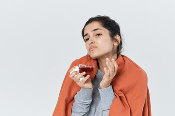 woman with a cold covered herself with a blanket tea treatment