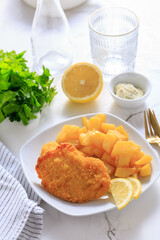 Chicken escalope with baked potatoes, mayonnaise and lemon