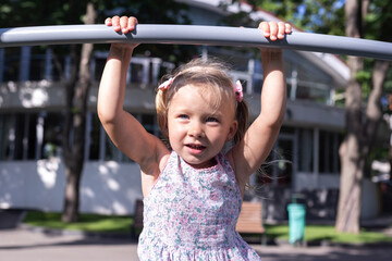 Fototapeta premium Cheerful child on the playground on a sunny day. Real people