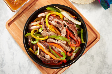 Fajitas de res con pimientos servidos con tortillas de maíz