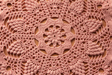 Beautiful closeup pink  crochet doily on wooden background