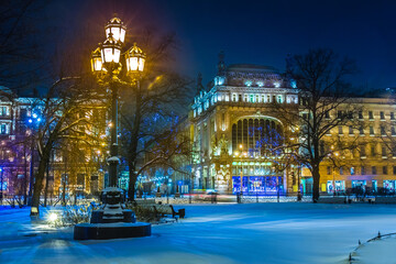 Fototapeta na wymiar Saint Petersburg. Russia. Winter evening in St. Petersburg. Nevsky prospect. Ostrovsky square is lit by lanterns. Eliseevsky shop. Lights of the evening city. Winter trip to Russia.