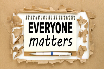 Everyone Matters, text on notepad near torn paper