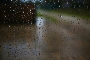 Rain droplets on window with out of focus background, close up