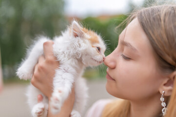 Portrait of a young beautiful blonde girl with a small kitten, close-up.