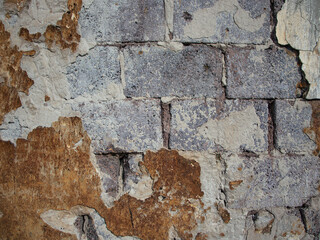 Old stone wall with face shaped pieces of plaster 