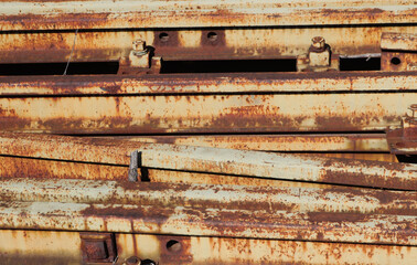 rusted and stacked metal rails of iron form a train station - rusty industrial texture for a background