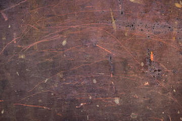 rusty metal plank with colorful scratches over a dark brown background - artistic effect texture