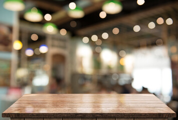 Empty wooden table top with lights bokeh on blur restaurant background.