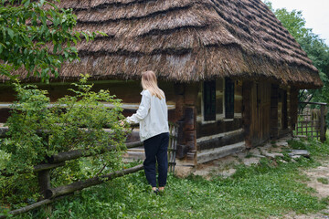 The beautiful girl traveler walks through the village. Beautiful nature landscape in countryside. Hiking journey on tourist trail. Outdoor adventure. Travel and exploration. Healthy lifestyle