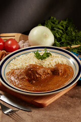 Pollo en pipián rojo con arroz blanco, platillo mexicano.