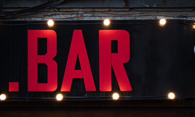 red bar sign, illuminated by lanterns. night