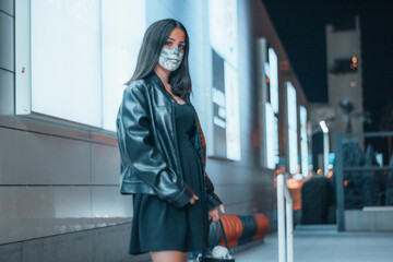 Obraz premium Niña vestida de un maquillaje tenebroso disfrazada en la noche en un centro comercial para realizar la festividad de el dia de Halloween con su cesta de caramelos